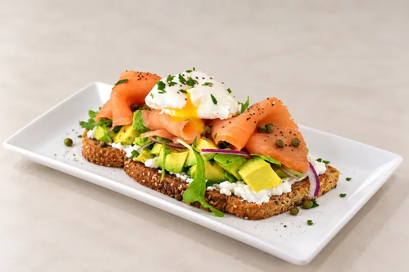 Nova salmon and avocado toast with a poached egg, capers and red onion
